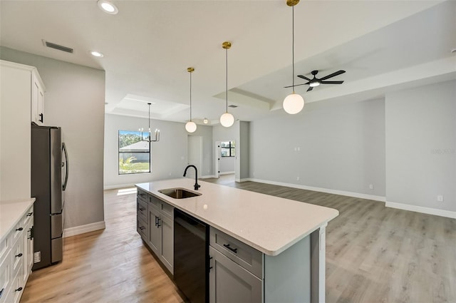 kitchen with sink, white cabinetry, stainless steel refrigerator, black dishwasher, and a raised ceiling