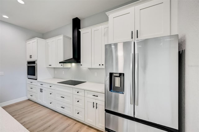 kitchen featuring white cabinets, wall chimney exhaust hood, and appliances with stainless steel finishes