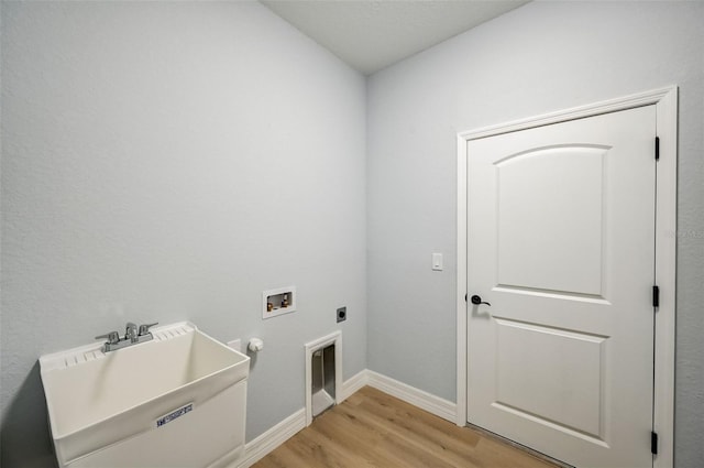 laundry area with electric dryer hookup, sink, hookup for a washing machine, and light hardwood / wood-style floors