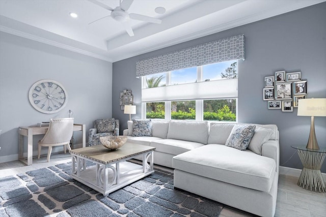 living room with ceiling fan and a raised ceiling