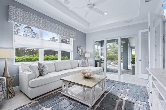 living room featuring ceiling fan and a tray ceiling