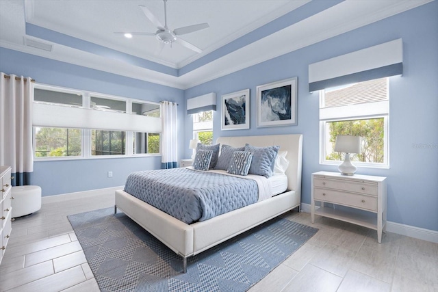 bedroom with ceiling fan, a raised ceiling, and ornamental molding