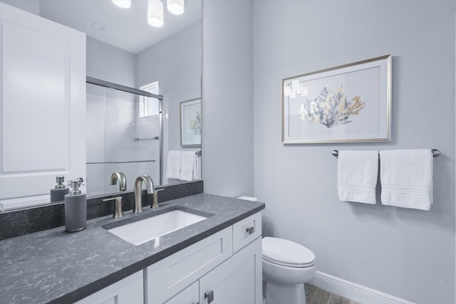 bathroom with vanity, toilet, and a shower with shower door