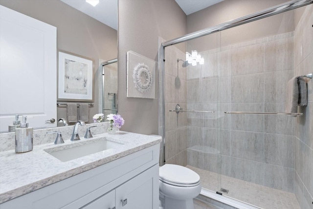 bathroom with vanity, toilet, and a shower with shower door