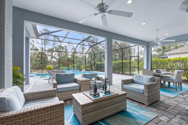 view of patio / terrace featuring an outdoor living space, glass enclosure, and ceiling fan