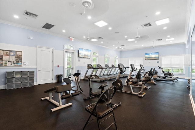 gym featuring ceiling fan, a healthy amount of sunlight, and crown molding