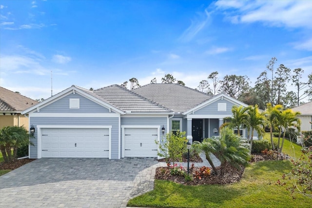 ranch-style home featuring a garage and a front lawn