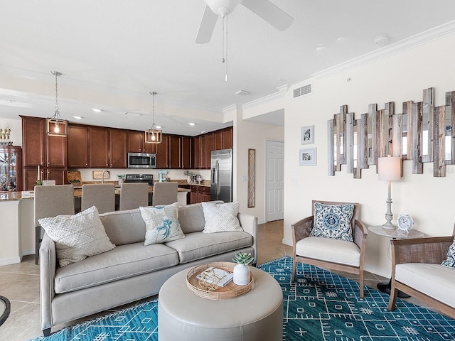 living room featuring ceiling fan, crown molding, and tile patterned flooring