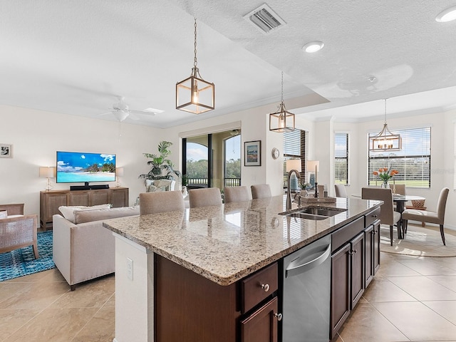 kitchen featuring sink, hanging light fixtures, dishwasher, and a center island with sink