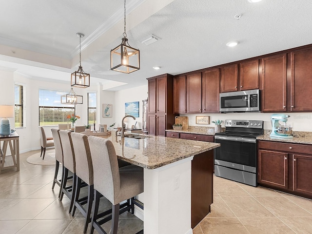 kitchen with sink, appliances with stainless steel finishes, a center island with sink, and crown molding