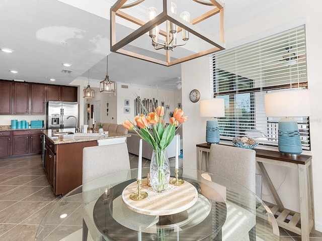 dining room featuring sink, a notable chandelier, and crown molding