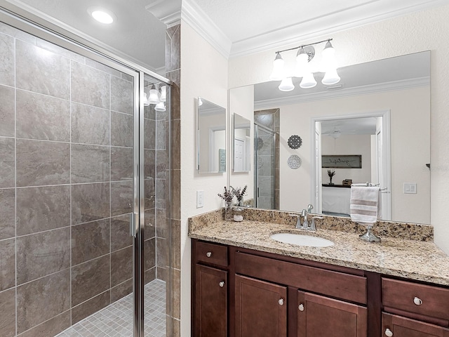 bathroom with a shower with shower door, vanity, and ornamental molding