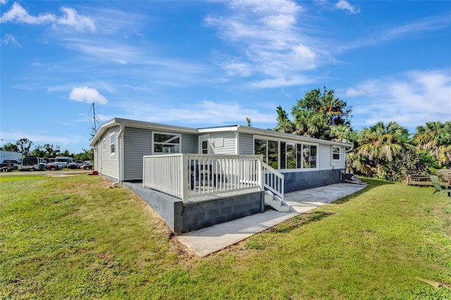 rear view of property with a deck and a yard