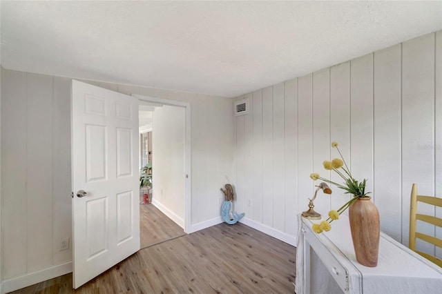 interior space with wood walls and hardwood / wood-style floors