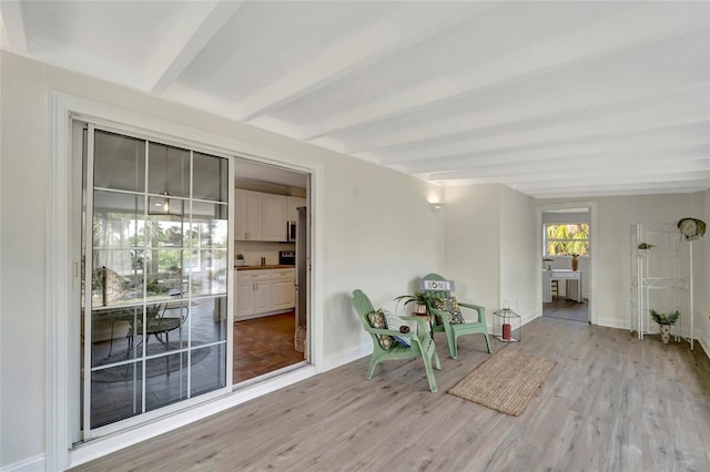 unfurnished room featuring light hardwood / wood-style flooring and beamed ceiling