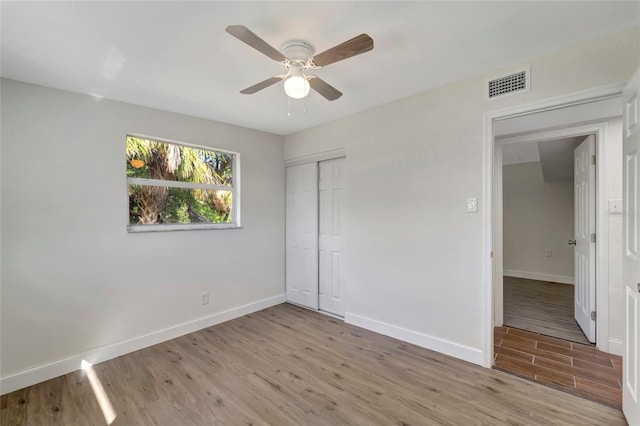 unfurnished bedroom with ceiling fan, a closet, and light hardwood / wood-style floors