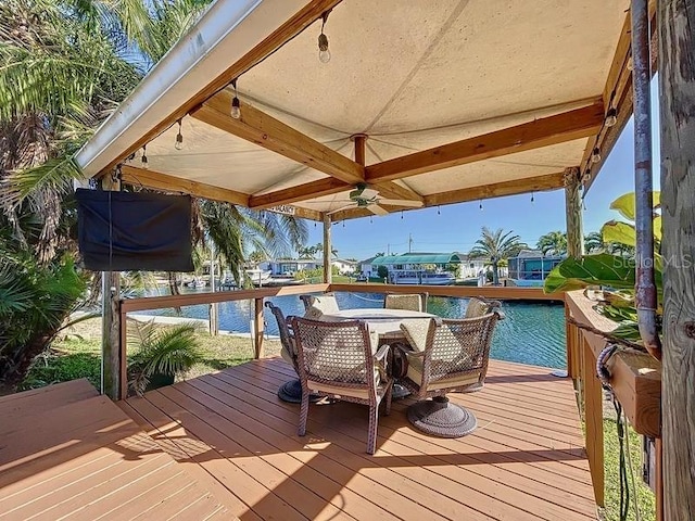 wooden deck featuring ceiling fan and a water view