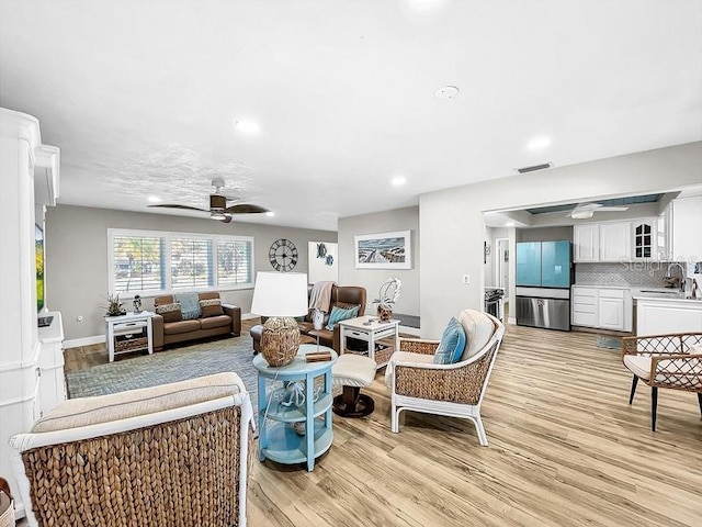 living room featuring light hardwood / wood-style floors and ceiling fan