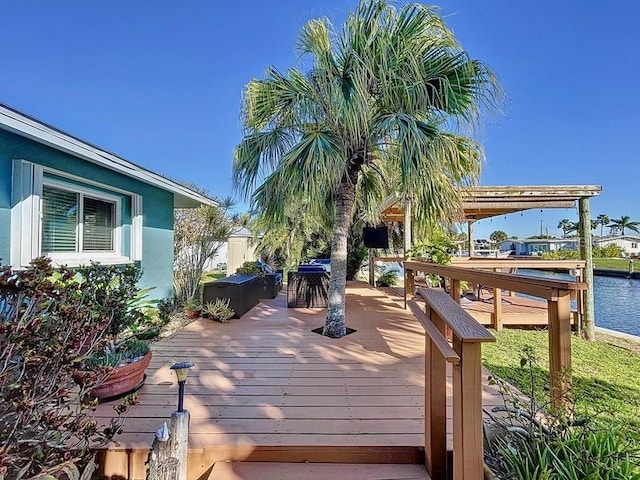 wooden terrace featuring a water view and outdoor lounge area