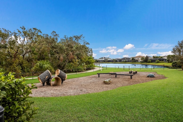 view of property's community with a lawn and a water view