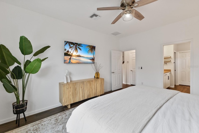 bedroom featuring dark hardwood / wood-style flooring, ensuite bathroom, and ceiling fan