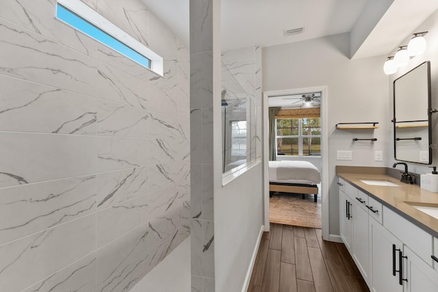 bathroom with vanity, ceiling fan, a wealth of natural light, and tiled shower