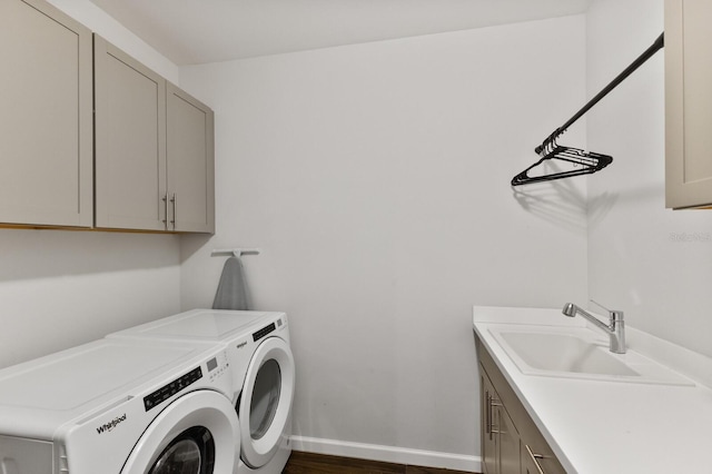 laundry room with independent washer and dryer, cabinets, and sink