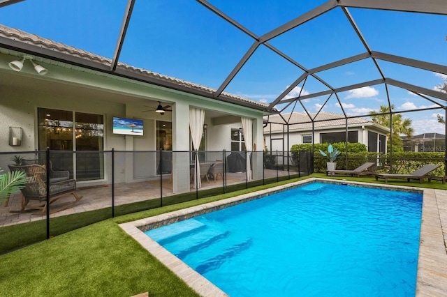 view of pool featuring a lanai, a patio area, ceiling fan, and a lawn