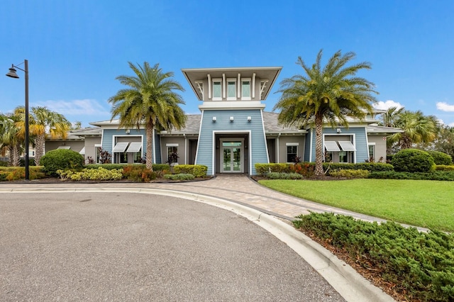 view of front facade with french doors and a front lawn