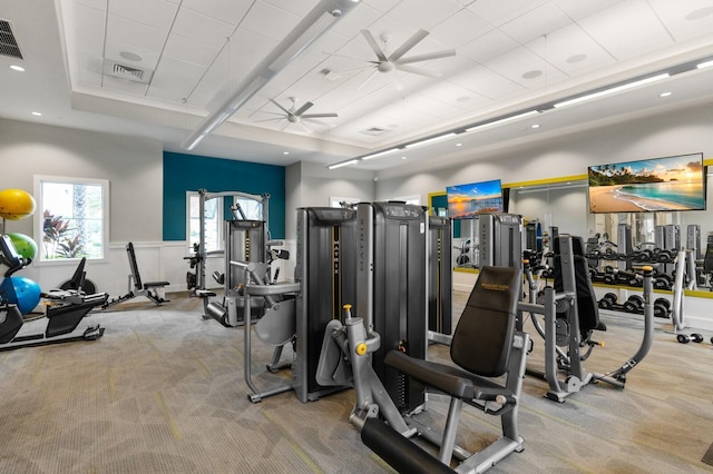 exercise room with light carpet and ceiling fan