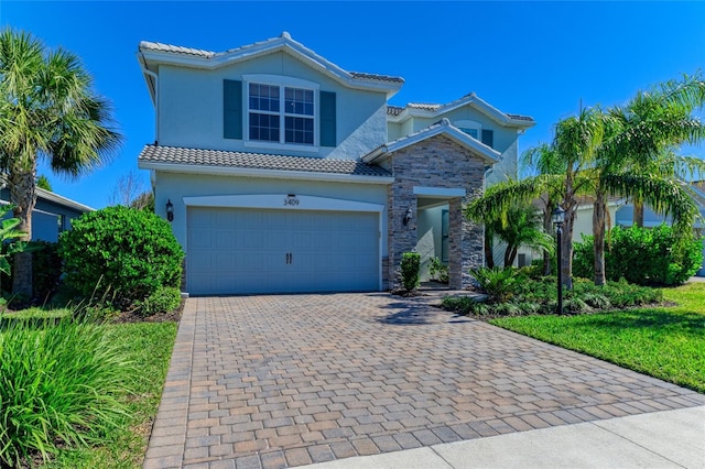 3409 Anchor Bay Trl, Lakewood Ranch, FL 34211 - mediterranean / spanish home with stone siding, stucco siding, driveway, a tile roof, and an attached garage