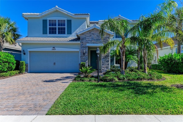 3409 Anchor Bay Trl, Lakewood Ranch, FL 34211 - view of front facade featuring stone siding, a tiled roof, decorative driveway, a front yard, and an attached garage