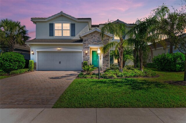 3409 Anchor Bay Trl, Lakewood Ranch, FL 34211 - view of front facade with stone siding, decorative driveway, stucco siding, a front lawn, and a tile roof