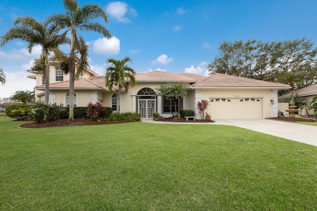 mediterranean / spanish-style house featuring a front lawn and a garage