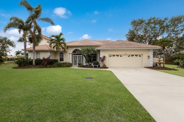 mediterranean / spanish home with a garage and a front yard