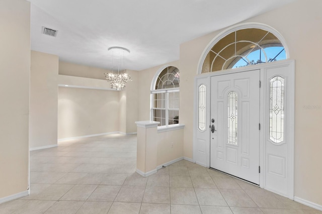 tiled entrance foyer with an inviting chandelier