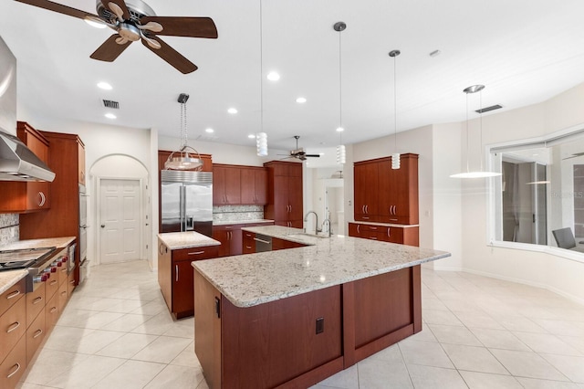 kitchen featuring stainless steel appliances, tasteful backsplash, a spacious island, hanging light fixtures, and light stone countertops