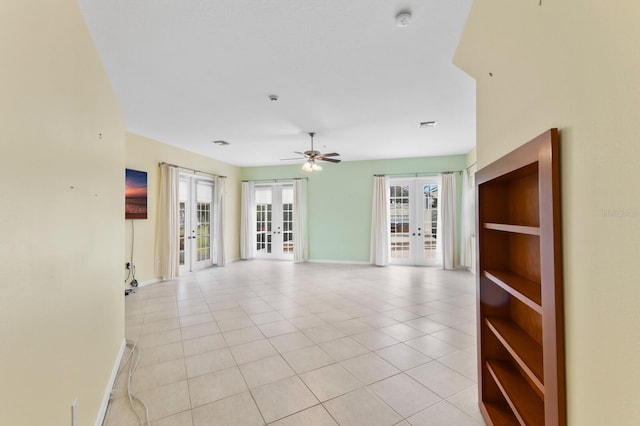 tiled spare room featuring ceiling fan and french doors