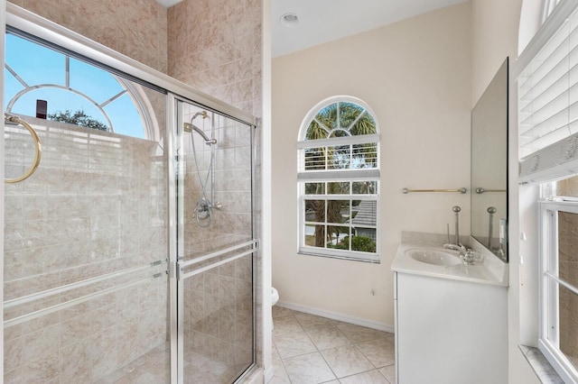 bathroom with tile patterned flooring, plenty of natural light, vanity, and an enclosed shower