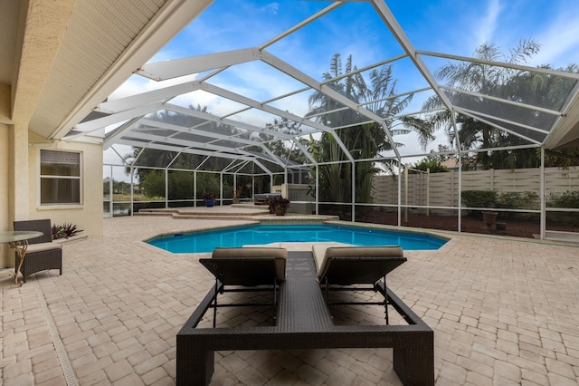 view of pool featuring glass enclosure and a patio