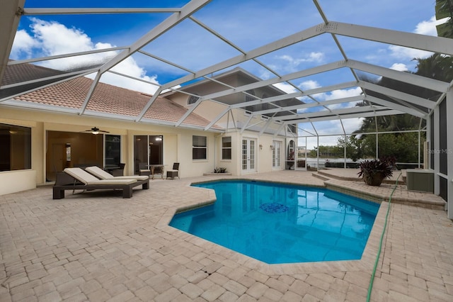 view of pool featuring ceiling fan, a patio area, and glass enclosure