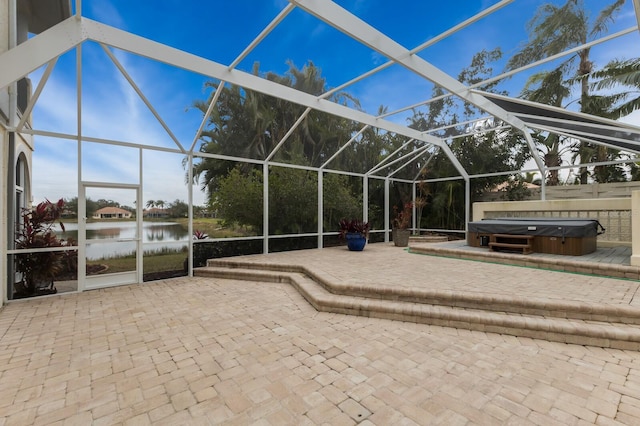 view of patio / terrace with a lanai, a water view, and a hot tub