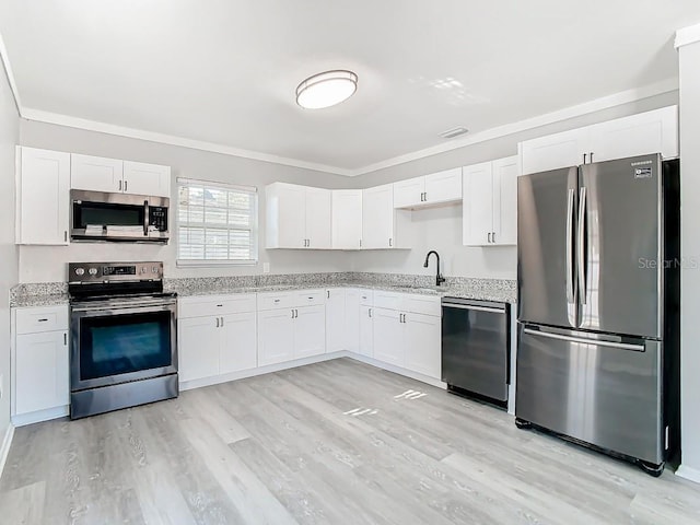 kitchen with light hardwood / wood-style floors, white cabinets, appliances with stainless steel finishes, and sink