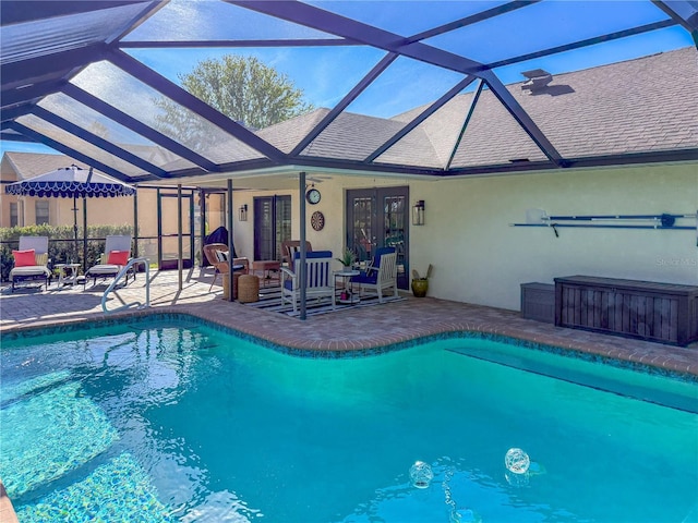 view of swimming pool with ceiling fan, glass enclosure, an outdoor hangout area, french doors, and a patio