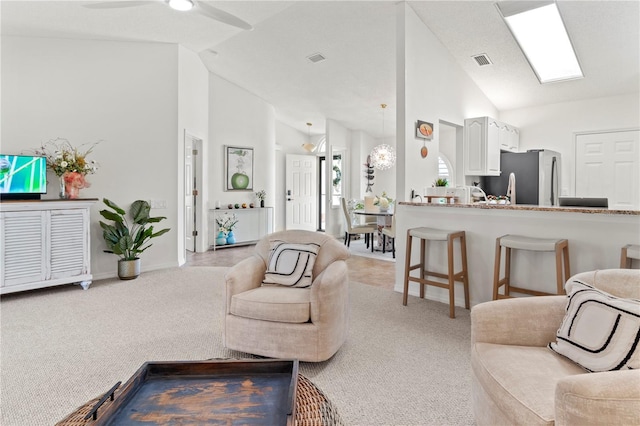 living room featuring light carpet, ceiling fan, and high vaulted ceiling