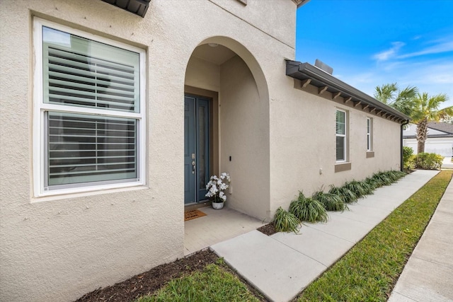 view of exterior entry with stucco siding