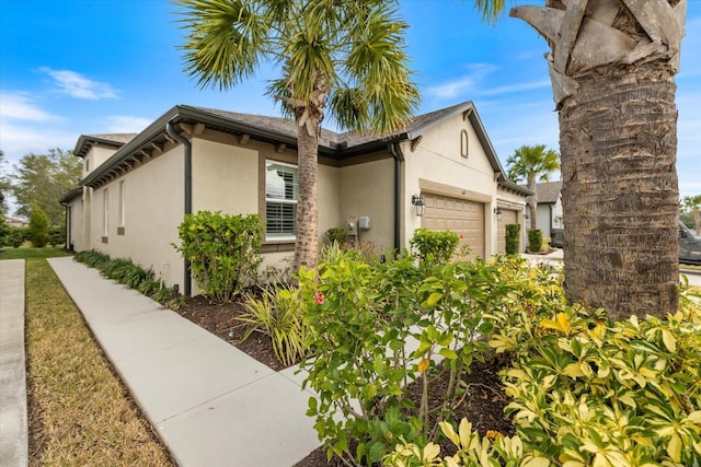 view of side of property featuring stucco siding and an attached garage