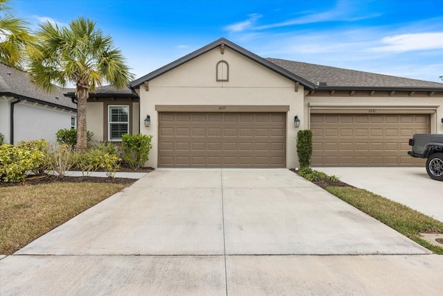 ranch-style home featuring stucco siding, roof with shingles, concrete driveway, and an attached garage