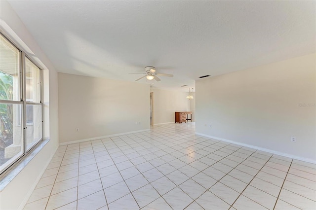 unfurnished room featuring a textured ceiling, ceiling fan, and light tile patterned floors