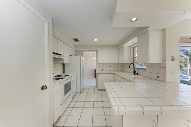 kitchen with white cabinetry, sink, white appliances, and tile counters